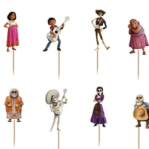 May include: A set of twelve decorative cupcake toppers featuring various animated characters from the movie Coco, including a dog, a boy with a guitar, skeletons in colourful clothing, and a winged creature, each attached to a thin wooden pick.