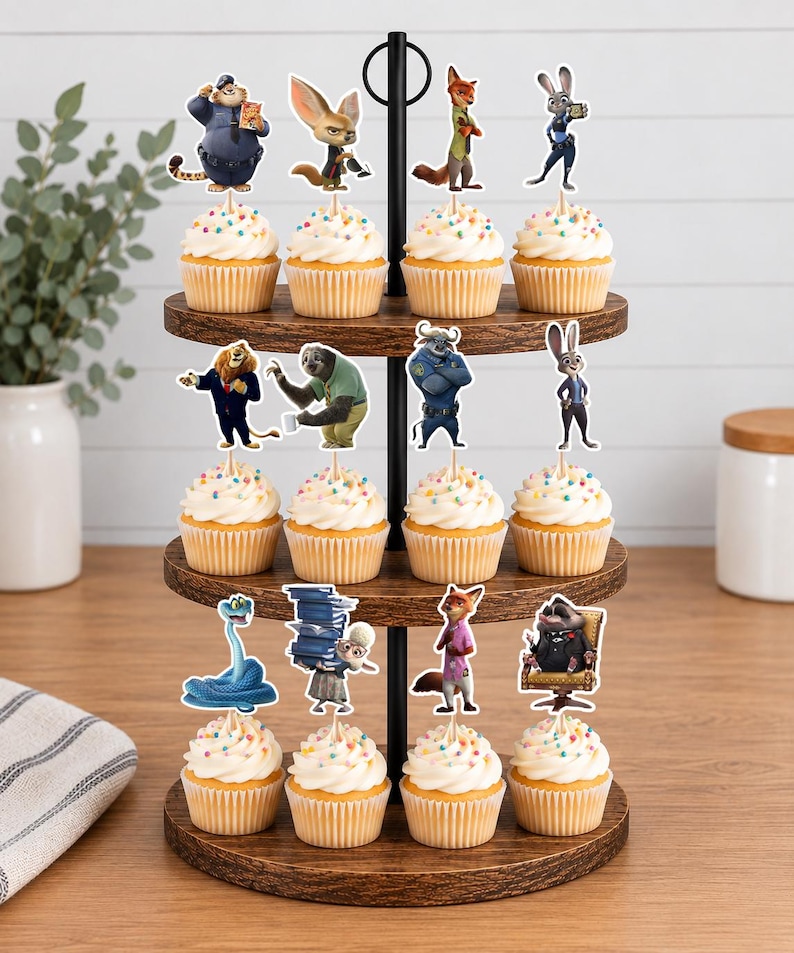 Pu&ograve; includere: Un'alzata per cupcake in legno a tre livelli con dodici cupcake guarniti con glassa bianca e zuccherini colorati. Ogni cupcake presenta un topper sagomato con un personaggio di Zootropolis, tra cui Judy Hopps, Nick Wilde, Flash e Chief Bogo.