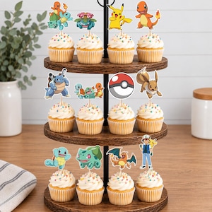 May include: A three-tiered wooden cupcake stand holding twelve cupcakes, each topped with a colorful paper cutout of various Pokemon characters, including Pikachu, Charmander, Squirtle, Bulbasaur, Eevee, Blastoise, Charizard, and a trainer figure.