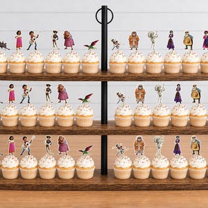 May include: A three-tiered wooden cupcake stand holding rows of cupcakes topped with various character cutouts. The toppers feature colourful illustrations of people, a dog, and a bird, arranged in repeating patterns across the three levels.