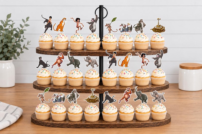 May include: A three-tiered wooden stand holding twenty-four cupcakes, each topped with a paper cutout of a character from The Jungle Book. The cupcakes feature white frosting with colorful sprinkles, arranged on dark brown oval wooden shelves.