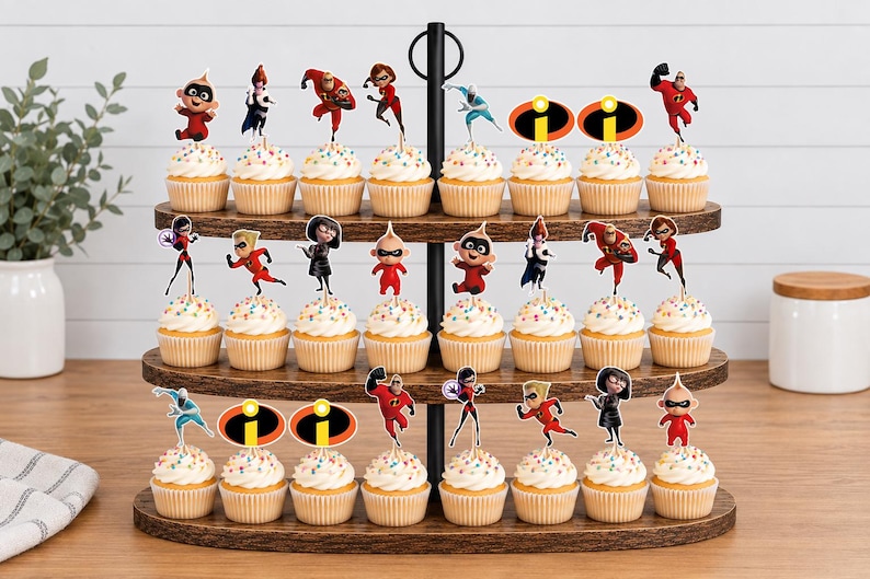 Op de afbeelding: Een houten cupcake-standaard met drie niveaus en vierentwintig cupcakes, elk voorzien van een papieren topper met personages en logo's uit The Incredibles. De cupcakes zijn voorzien van witte glazuur met kleurrijke spikkels.