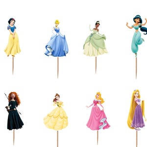 May include: A set of twelve decorative cupcake toppers featuring various animated female characters in colorful gowns and outfits, each attached to a thin wooden toothpick. The characters include figures in blue, yellow, green, teal, and pink dresses.