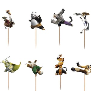 May include: A set of twelve decorative cupcake toppers featuring various Kung Fu Panda characters, including Po, Master Shifu, Tigress, and others, each attached to a thin wooden toothpick for insertion into food items for themed party displays.