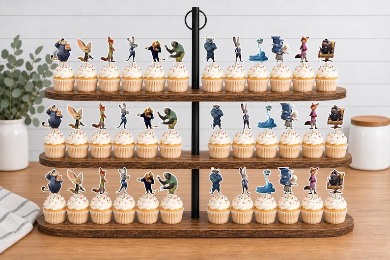 Pu&ograve; includere: Un'alzata per cupcake in legno a tre livelli che contiene trentasei cupcake, ognuno sormontato da un topper di carta raffigurante un personaggio di Zootropolis. Il supporto presenta un manico centrale in metallo nero e ripiani ovali.