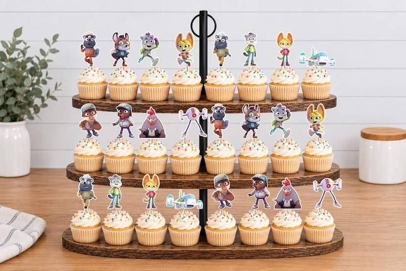 Puede incluir: Un soporte de madera para cupcakes de tres niveles con veintid&oacute;s cupcakes, cada uno decorado con un recorte de papel colorido de un personaje o veh&iacute;culo animado. Los cupcakes tienen glaseado blanco con chispas multicolores en moldes de papel.