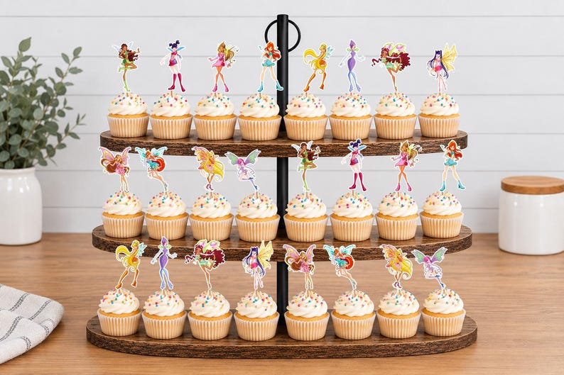 May include: A three-tiered wooden cupcake stand holding twenty-four cupcakes, each topped with a colorful paper cutout of a fairy character. The stand features a black metal central pole and handle, displaying a variety of animated character designs.