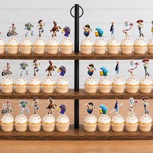 Puede incluir: Un soporte de madera para cupcakes de tres niveles con treinta y seis cupcakes, cada uno coronado con un recorte de papel decorativo que presenta varios personajes animados, incluyendo un guardi&aacute;n espacial, un vaquero, un caballo y un tenedor.