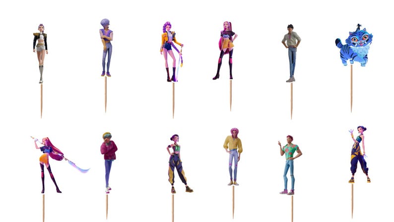 Op de afbeelding: Een set van twaalf decoratieve cupcake-toppers met diverse geanimeerde figuren en een blauw tijgerachtig wezen, elk bevestigd aan een dunne houten tandenstoker. De figuren tonen uiteenlopende outfits, kapsels en houdingen in kleur.