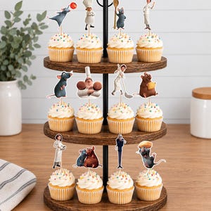 May include: A three-tiered wooden cupcake stand holding twelve cupcakes topped with white frosting and colorful sprinkles. Each cupcake features a decorative paper topper depicting various characters and culinary items from the movie Ratatouille.