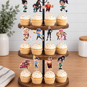 May include: A three-tiered wooden cupcake stand holding twelve cupcakes topped with white frosting and colorful sprinkles. Each cupcake features a Wreck-It Ralph character cutout topper, including Ralph, Vanellope, Felix, and other movie figures.