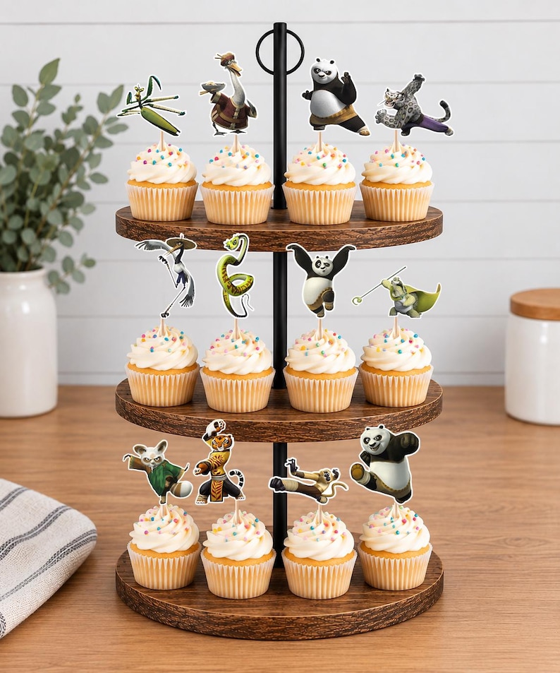 May include: A three-tiered wooden cupcake stand holding twelve cupcakes, each topped with a paper cutout of a Kung Fu Panda character. The cupcakes feature white frosting with colorful sprinkles, arranged on dark brown circular wooden trays.