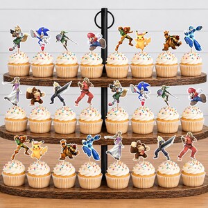 Pu&ograve; includere: Un'alzata per cupcake in legno a tre livelli contenente ventiquattro cupcake, ognuno sormontato da una sagoma di carta colorata raffigurante un personaggio dei videogiochi. I personaggi includono Mario, Sonic, Pikachu, Link e altri ancora.