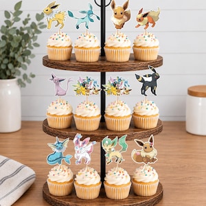 May include: A three-tiered wooden cupcake stand holding twelve cupcakes topped with white frosting, colorful sprinkles, and various character-themed paper toppers featuring diverse creatures in shades of yellow, blue, brown, pink, and black.