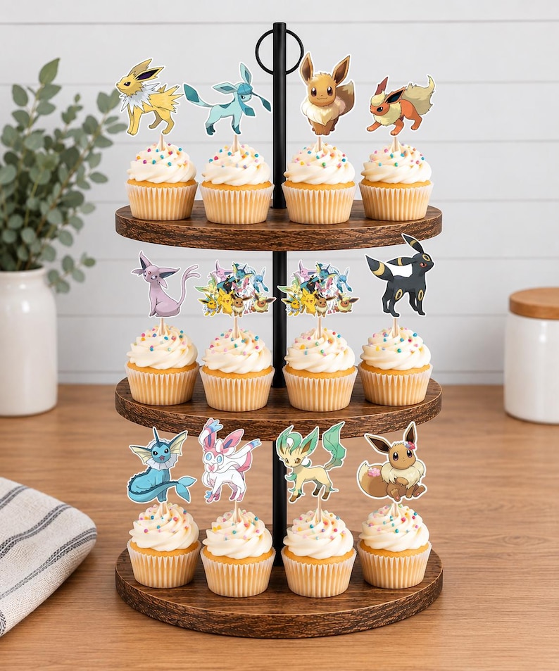 May include: A three-tiered wooden cupcake stand holding twelve cupcakes topped with white frosting, colorful sprinkles, and various character-themed paper toppers featuring diverse creatures in shades of yellow, blue, brown, pink, and black.