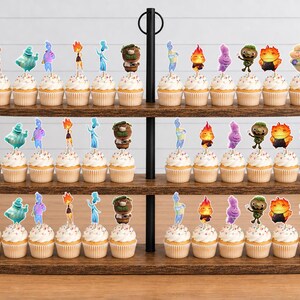 May include: A three-tiered wooden cupcake stand holding numerous cupcakes topped with colourful character toppers. The toppers feature various animated figures in shades of blue, orange, purple, green, and yellow, arranged in rows on each wooden shelf.