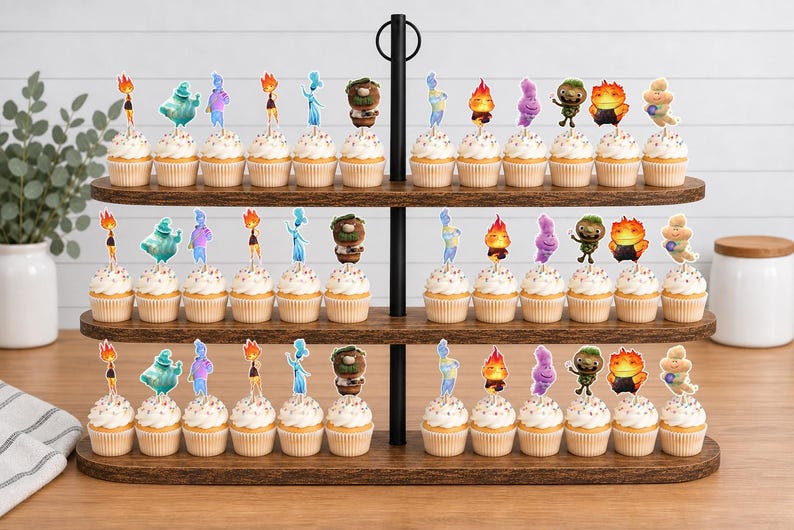May include: A three-tiered wooden cupcake stand holding numerous cupcakes topped with colourful character toppers. The toppers feature various animated figures in shades of blue, orange, purple, green, and yellow, arranged in rows on each wooden shelf.