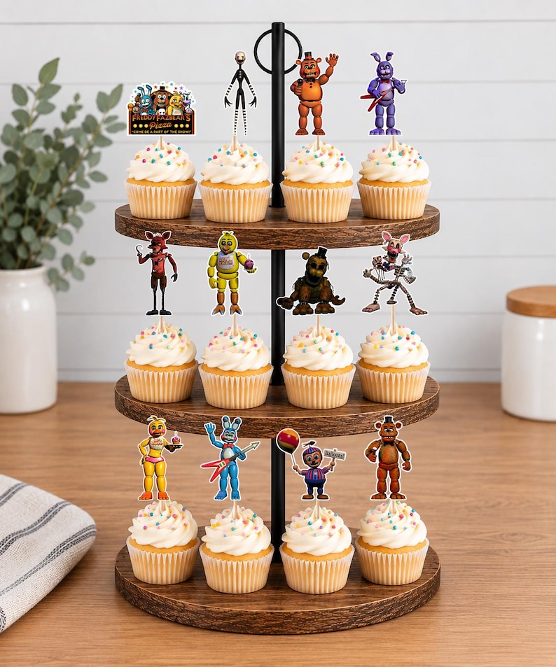 May include: A three-tiered wooden cupcake stand holding twelve cupcakes topped with colourful sprinkles and Five Nights at Freddy's character toppers. The top tier features a sign reading Freddy Fazbear's Pizza Come Be A Part Of The Show.
