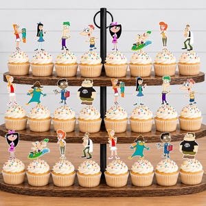 May include: A three-tiered wooden cupcake stand holding twenty-four cupcakes, each topped with a colorful paper cutout of characters from Phineas and Ferb, including Phineas, Ferb, Isabella, Candace, Perry the Platypus, and Dr. Doofenshmirtz.