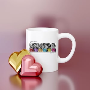K&ouml;nnte beinhalten: Wei&szlig;e Keramiktasse mit einem Schwarzwei&szlig;bild einer Band mit dem Text "Heathens" und "God, Soul, God, Fury, God" in bunter Schrift. Die Tasse hat einen schwarzen Henkel.