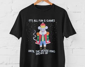May include: Black t-shirt featuring a cartoon mouse dressed as a king, wearing a crown and cape. The shirt has the text "IT'S ALL FUN & GAMES" above the mouse and "UNTIL THE MOUSE KING SHOWS UP" below.