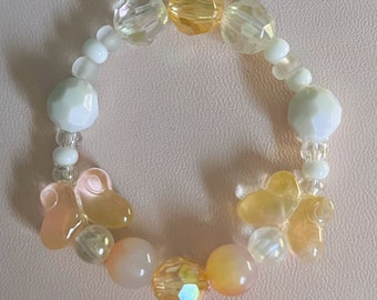 Pulsera de cuentas de mariposa con cuentas blancas y amarillas/naranjas.