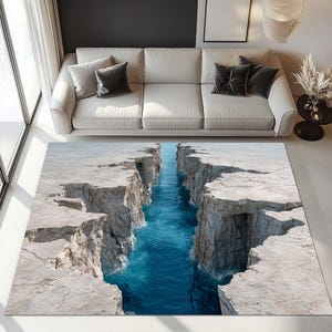 Könnte beinhalten: Rechteckiger Teppich mit einem realistischen Design eines tiefblauen Ozeancanyons. Der Teppich zeigt die Canyonwände und das Wasser darunter. Der Teppich befindet sich in einem Wohnzimmer, mit einem Sofa sichtbar.