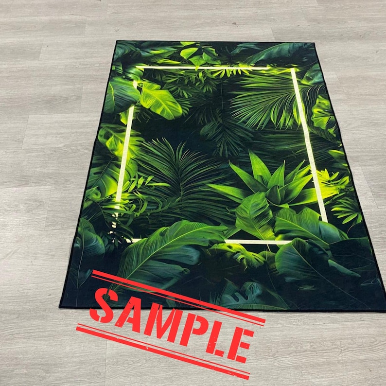 May include: Rectangular rug featuring a vibrant green tropical leaf pattern with a white rectangular border. The rug has a black border and the word "SAMPLE" is stamped across the bottom in red.