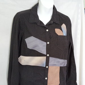 May include: A black button-down shirt with a polka dot pattern. The shirt has multiple tie patterns sewn onto the front.