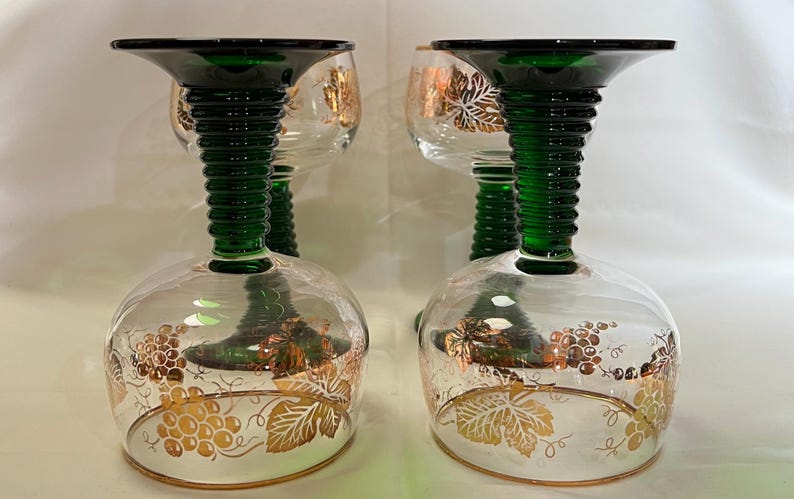 Puede incluir: Una taza de cer&aacute;mica blanca con un asa negra y el texto "But First, Coffee" en negrita negra. La taza se encuentra sobre un fondo borroso, sugiriendo un ambiente acogedor.