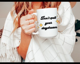 May include: White ceramic mug with black text that reads "Don't quit your daydream" with yellow star accents.