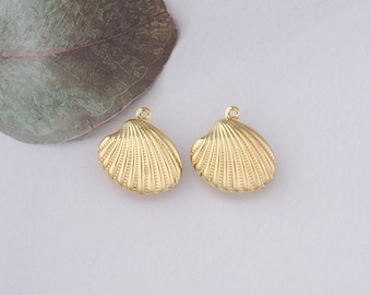 May include: Two gold-coloured metal seashell charms with a textured surface. The charms have a loop at the top for attaching to jewellery.