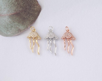 May include: Three silver, gold, and rose gold jellyfish charms with clear crystal accents. The charms are detailed with a dome-shaped top and dangling tentacles.
