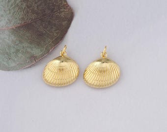 May include: Two gold-coloured seashell charms with a textured surface. The charms have a loop at the top for attaching to jewellery.