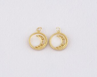 May include: Two gold-colored moon-shaped pendants. Each pendant features a crescent moon design within a circular frame. The frame has a beaded edge and small star-like accents. The background of the moon is white.