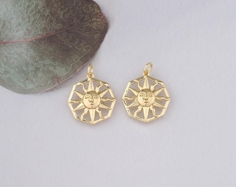 May include: Two gold-toned sun charm pendants with a face and rays. The charms are octagonal in shape and have a detailed design.