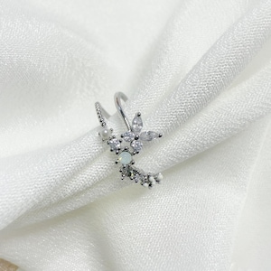 May include: A silver ring with a delicate butterfly design featuring clear and white stones.