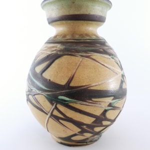 May include: A ceramic vase with a brown, yellow and green abstract design. The vase has a rounded body and a narrow neck.