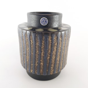 May include: A black and gold striped ceramic vase with white dots and a blue and white label that reads "Upsala Ekeby Sweden LE".