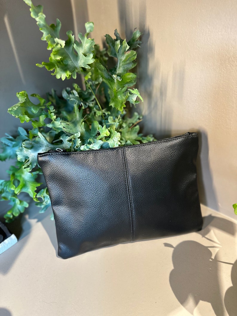 Pochette porta tutto in pelle ecologica con personalizzazione con iniziali ricamate.