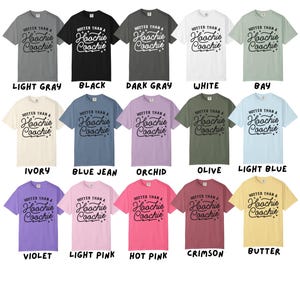 Puede incluir: Una colecci&oacute;n de camisetas en varios colores, cada una con el texto "HOTTER THAN A Hoochie Coochie" en una fuente cursiva. Los colores incluyen gris claro, negro, gris oscuro, blanco, bah&iacute;a, marfil, azul vaquero, orqu&iacute;dea, oliva, azul claro, violeta, rosa claro, rosa intenso, carmes&iacute; y mantequilla.