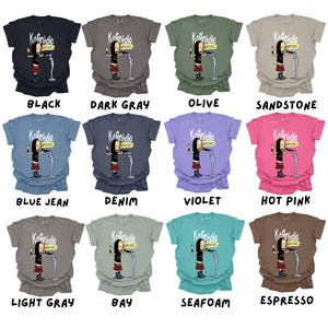 May include: A collage of 12 t-shirts in various colors, each featuring a cartoon character with a microphone and the text "Kaanholio" on the front. The colors include black, dark gray, olive, sandstone, blue jean, denim, violet, hot pink, light gray, bay, seafoam, and espresso.