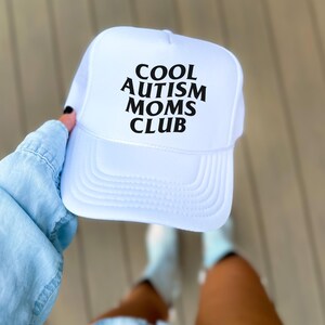 May include: White trucker hat with black text that reads "COOL AUTISM MOMS CLUB".
