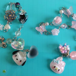 May include: A colorful charm bracelet with a variety of charms, including hearts, stars, butterflies, and a small dog. The bracelet is made of silver chain and has a clear glass bead with colorful sprinkles inside.