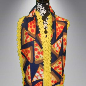 May include: A fleece scarf with a pizza print and yellow crocheted trim. The scarf is displayed on a mannequin.