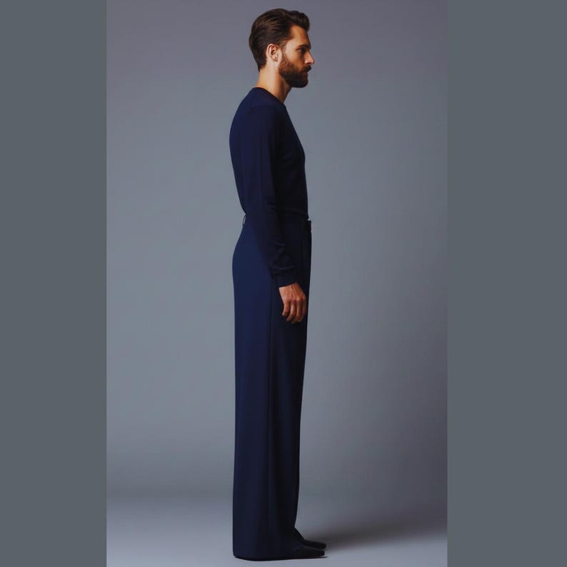 May include: A navy blue long-sleeve shirt and matching wide-leg pants. The outfit is a solid color and appears to be made of a smooth fabric. The model is standing in profile against a gray background.