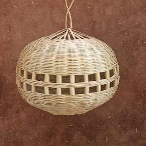 May include: A round, woven, light brown wicker lampshade with a woven handle.