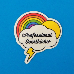 Puede incluir: Una pegatina blanca con un arcoíris, un sol y un bocadillo que dice "Professional Overthinker".