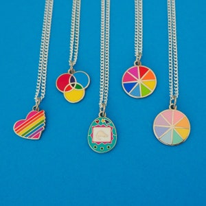 Five silver curb-chain necklaces, each with an enamel charm pendant. The pendants are of different colourful designs.