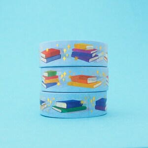 Light blue washi tape printed with small stacks of colourful books and gold-foil sparkles.
